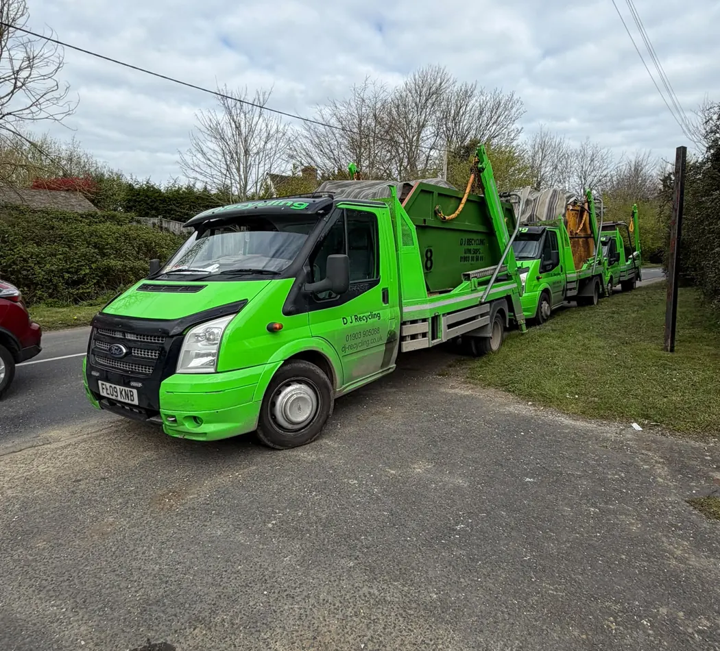 DJ Recycling's bright green skip lorries parked together on a local job