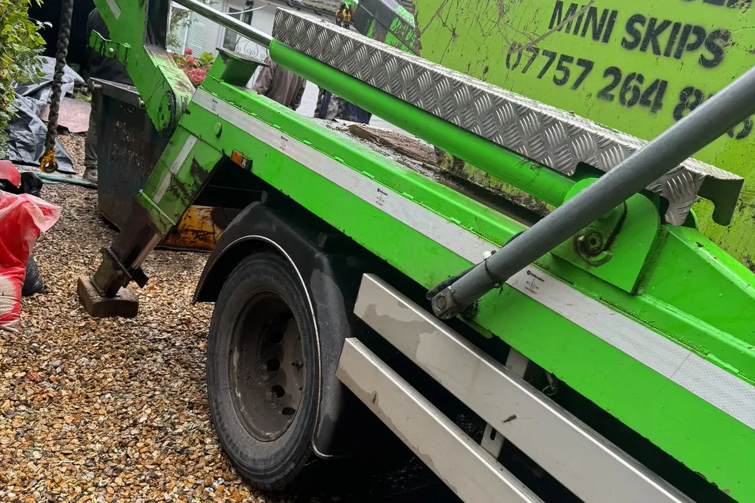 DJ Recycling collecting a skip from a gravel driveway